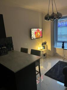 a living room with a table and a tv on the wall at Albert House in Airdrie