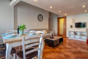 uma sala de estar com uma mesa e um sofá em Sa Domo Apartments em Alghero