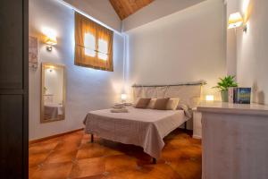 a bedroom with a bed with a table and a mirror at Sa Domo Apartments in Alghero