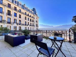 eine Terrasse mit einem Tisch und Stühlen vor einem Gebäude in der Unterkunft Appartement bourgeois avec terrasse et vue lac in Aix-les-Bains