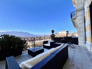 a balcony with blue benches and a view of the city at Appartement bourgeois avec terrasse et vue lac in Aix-les-Bains