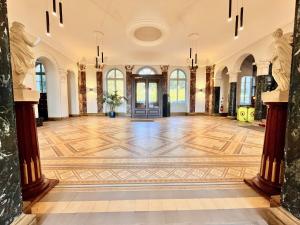 a large hall with a wooden floor in a building at Appartement bourgeois avec terrasse et vue lac in Aix-les-Bains