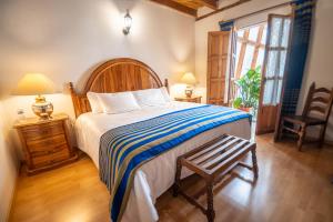 a bedroom with a bed and a chair and a table at Hotel Rincon de Josefa in Pátzcuaro