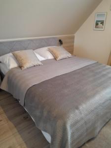 sypialnia z dużym łóżkiem z białymi poduszkami w obiekcie Domek pod Brzozami z jacuzzi ,grillem i tarasem w mieście Przemyśl