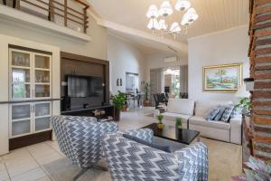 uma sala de estar com um sofá e uma televisão em Casa com churrasq, piscina e Wi-Fi em Criciuma SC em Criciúma