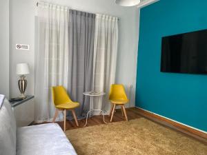 a bedroom with two yellow chairs and a blue wall at Lait Hostel in Ioannina