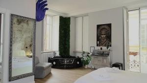 un salon avec un miroir et une chambre avec un arbre dans l'établissement Apartments Chic Torino Centro, à Turin