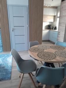 - une cuisine avec une table et des chaises dans la chambre dans l'établissement Domek pod Brzozami z jacuzzi ,grillem i tarasem, à Przemyśl