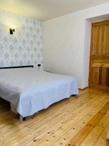 a bedroom with a bed and a wooden floor at Kazbegi Palace in Kazbegi
