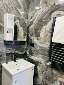 a bathroom with a sink and a rock wall at Kazbegi Palace in Kazbegi