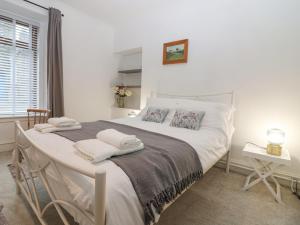 Un dormitorio con una cama blanca con toallas. en 16 Main Street, en Ellon