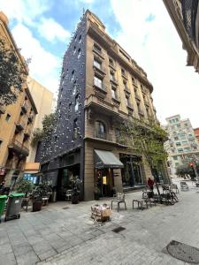 un edificio alto con una gran torre en una calle de la ciudad en Acogedor piso en el corazón de la ciudad con patio exclusivo, en Barcelona