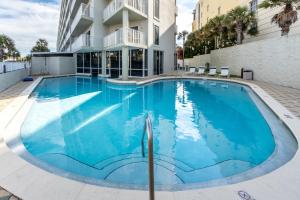 a large blue swimming pool in front of a building at Seacrest 610 is a 2 BR Gulfside on Okaloosa Island condo in Fort Walton Beach