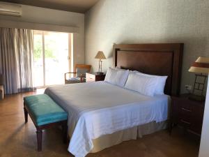 a bedroom with a large bed and a large window at San Angel Suites in Cabo San Lucas