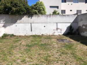 a concrete wall with a grassy field next to a building at Duplex 300 m del mar Barapoint in Necochea +9 photos