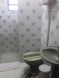 a bathroom with a green toilet and a sink at CASA COM PISCINA EM BALNEÁRIO PINHAL RS in Pinhal