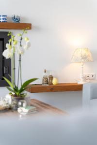 a table with a lamp and flowers on a shelf at Ioannis House in Sellía