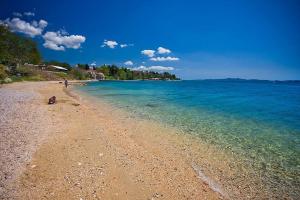 a beach with a person sitting on the shore at Apartment Maky in Zadar