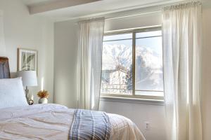 een slaapkamer met een bed en een raam met een met sneeuw bedekte berg bij Charming Orem Townhome 5 Mi to BYU! in Orem