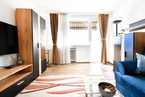 a living room with a blue couch and a tv at Fully Equipped Nomad Friendly Amazing Views in Sofia