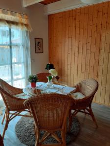 a dining room table with wicker chairs and a table and chairsktop at Ferienwohnung Bodensee in Hohenfels