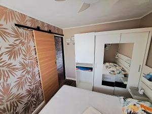 ein kleines Schlafzimmer mit einem Bett und einem Spiegel in der Unterkunft Appartement avec parking Cap d'Agde, La Falaise in Cap d'Agde
