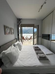 1 dormitorio con 1 cama blanca grande y balcón en Ocean views, en Plataria