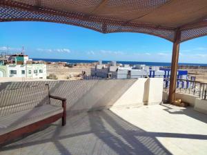 a balcony with a bench and a view of the ocean at Guest House Alam w in Marsa Alam City