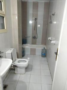 a bathroom with a toilet and a tub and a sink at Guest House Alam w in Marsa Alam City