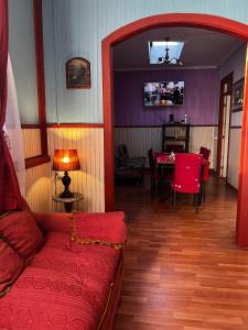 sala de estar con sofá rojo y mesa en Casa central 2 en Punta Arenas
