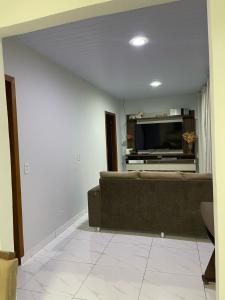 sala de estar con sofá y TV de pantalla plana en Casa c/ piscina e edícula, en Foz do Iguaçu