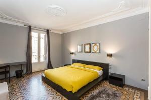 a bedroom with a bed with a yellow blanket at Ronda Sant Pere in Barcelona