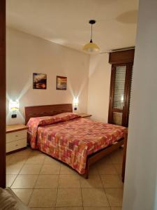 ein Schlafzimmer mit einem Bett und zwei Nachttischen und zwei Lampen in der Unterkunft Casa Ponente e Casa Levante in Buggerru