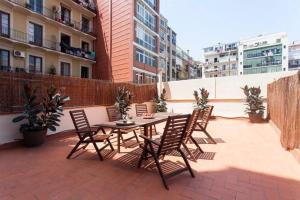 een patio met een tafel en stoelen op het dak bij Stylish and centric 2-bedroom apartment in Eixample &Terrace P2 in Barcelona