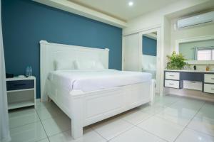 1 dormitorio con cama blanca y pared azul en Hotel Mar Azul 