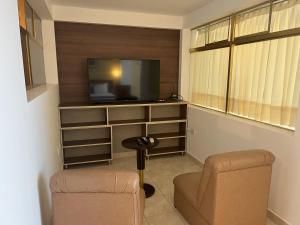 a living room with a tv and a chair at Lucky Star Hotel in Chiclayo
