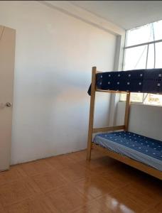 Ce lit superposé se trouve dans un dortoir doté d'une fenêtre. dans l'établissement Sand house, à Máncora