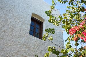 una ventana en el lateral de un edificio con flores en The Lady of Flakopi, en Pachaina