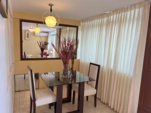 Lucky Star Hotel في تشيكلايو: غرفة طعام مع طاولة وكراسي ومرآة