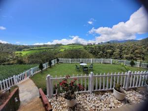 a balcony with a white fence and a table and bench at Charley's Heaven Ambewela in Ambawela