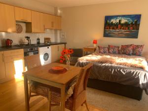 a bedroom with a bed and a table and a kitchen at Neema in Barnstaple