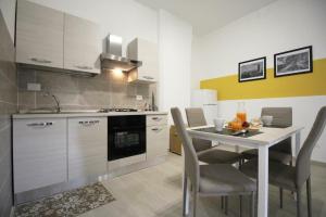 een keuken met een tafel met stoelen en een wastafel bij Casa vacanze Barbera in Sutri