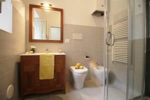 een badkamer met een toilet, een wastafel en een spiegel bij Casa vacanze Barbera in Sutri