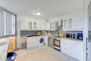 a large kitchen with white cabinets and appliances at Chic apartment with parking in Saint-Germain-en-Laye