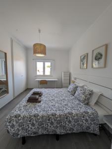 a white bedroom with a bed and a couch at Casa Oliveira in Sagres