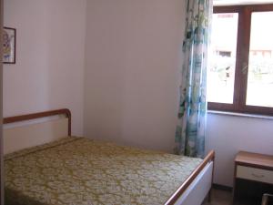 a bedroom with a bed and a window at Borgo Spiaggia Isola Rossa in Isola Rossa