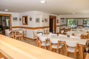 un comedor con mesas y sillas blancas en Complejo Base 41 en San Carlos de Bariloche