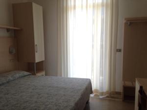 ein Schlafzimmer mit einem Bett und einem großen Fenster in der Unterkunft Hotel Lazzarini in Bellaria-Igea Marina