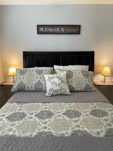 Una cama con dos almohadas y un cartel que dice bendice nuestra casa en Charming 2-Bedroom House for a Peaceful Getaway, en Cheyenne 7 fotos más