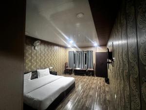 a bedroom with a large bed and a radiator at Hotel The Amar Grand in Mussoorie +29 photos